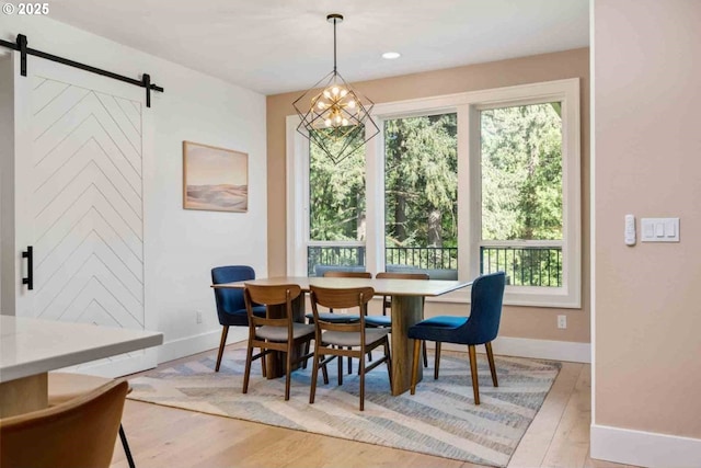 dining area with a healthy amount of sunlight, baseboards, and a barn door