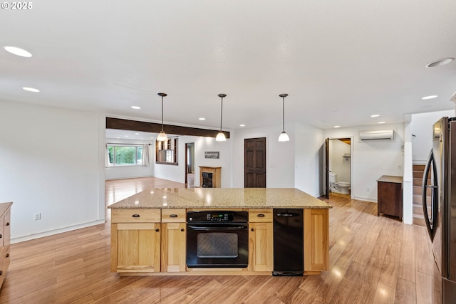 kitchen with light stone counters, a wall unit AC, oven, open floor plan, and freestanding refrigerator