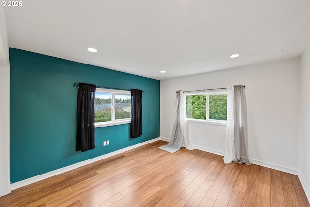 unfurnished room featuring light wood-style floors, recessed lighting, and baseboards