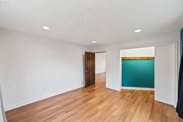 empty room with light wood-style floors, baseboards, and recessed lighting