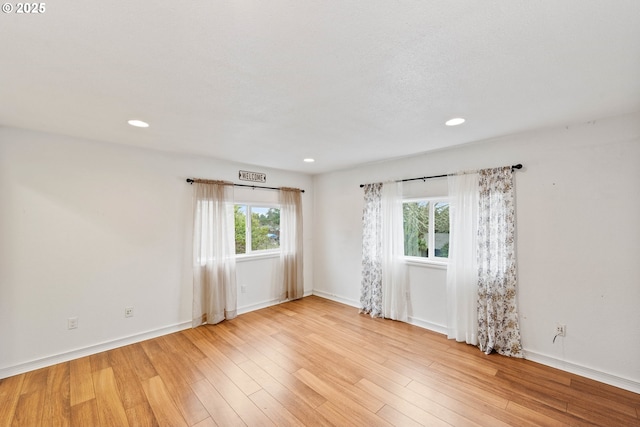 unfurnished room with light wood-style floors, recessed lighting, and baseboards