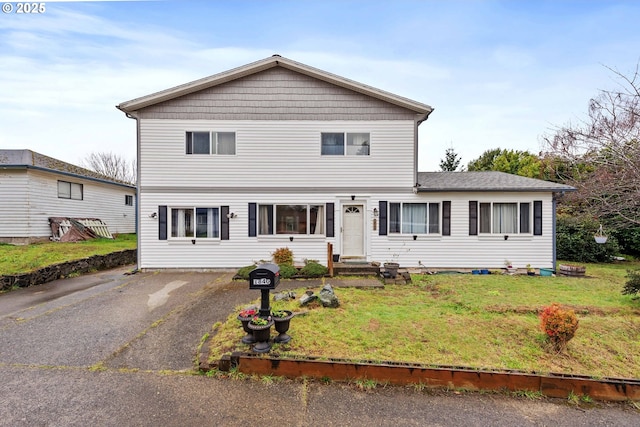 traditional-style home featuring driveway and a front lawn