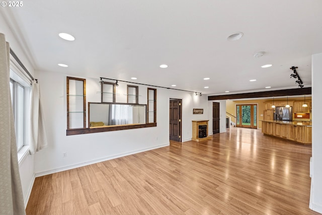 unfurnished living room featuring plenty of natural light, light wood-type flooring, a fireplace, and recessed lighting