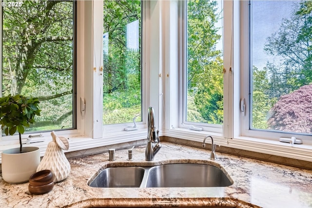 room details featuring light stone counters and a sink