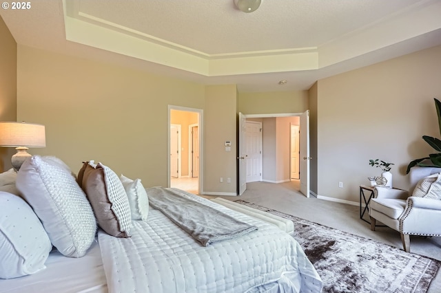 bedroom featuring light colored carpet, a raised ceiling, and baseboards