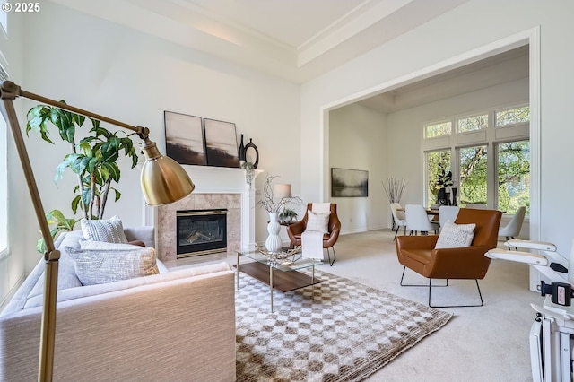 living area with a high end fireplace, baseboards, and carpet flooring