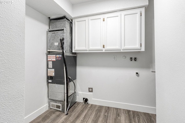 laundry area featuring cabinet space, baseboards, wood finished floors, hookup for an electric dryer, and washer hookup