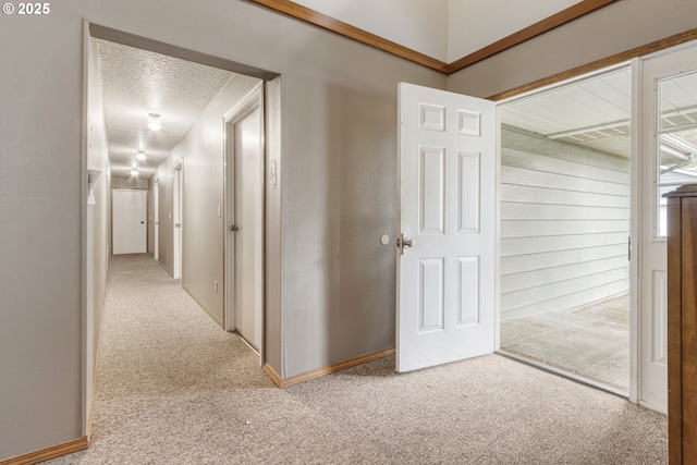 hall featuring a textured ceiling and carpet floors