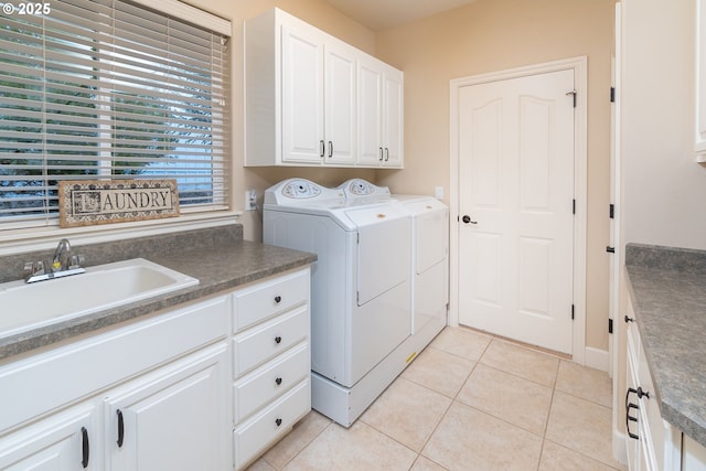 laundry room featuring cabinet space, a sink, washing machine and clothes dryer, and light tile patterned flooring