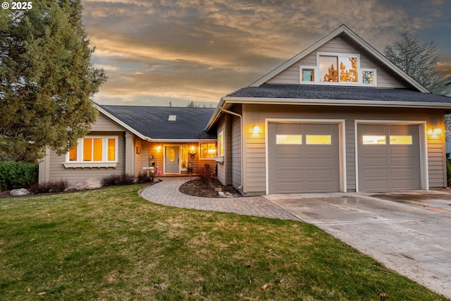 view of front of home featuring a garage, driveway, a shingled roof, and a lawn