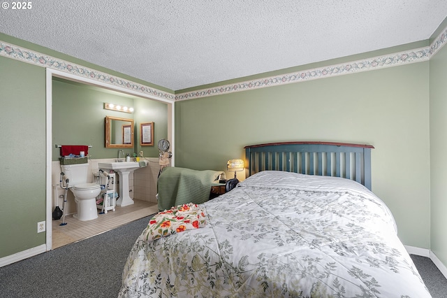carpeted bedroom featuring a sink and a textured ceiling