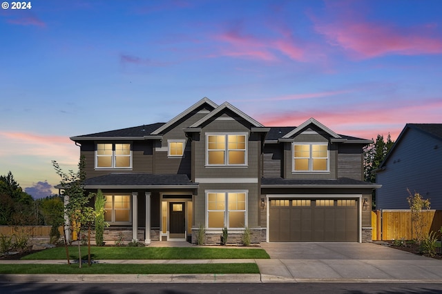 craftsman inspired home with fence, driveway, stone siding, an attached garage, and a yard