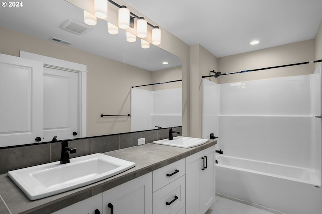 full bath featuring visible vents, a sink, washtub / shower combination, and double vanity