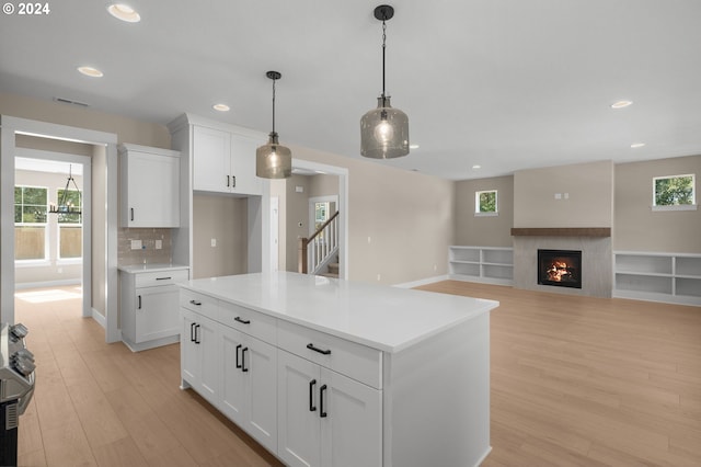 kitchen featuring light wood-type flooring, recessed lighting, light countertops, white cabinets, and hanging light fixtures