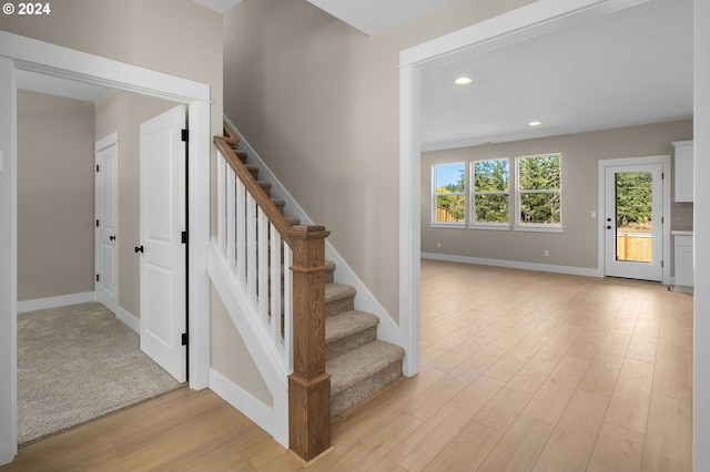 stairs with baseboards, recessed lighting, and wood finished floors