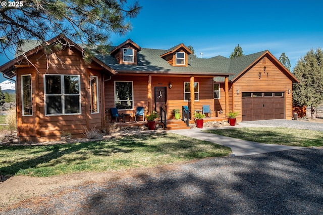 16830 Delicious St, Bend, OR 97703 - view of front of house featuring a porch, driveway, a front yard, and a garage