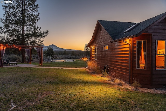 16830 Delicious St, Bend, OR 97703 - view of side of home featuring a shingled roof, a yard, a pergola, and a mountain view