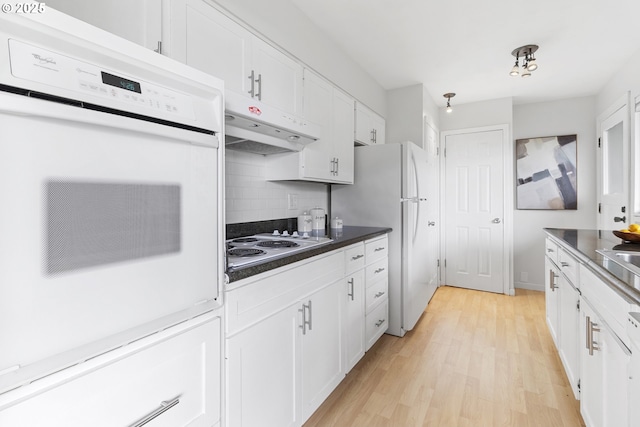 3038 SW Florida Ct Unit B, Portland, OR 97219 - kitchen featuring white appliances, white cabinetry, backsplash, light wood finished floors, and dark countertops