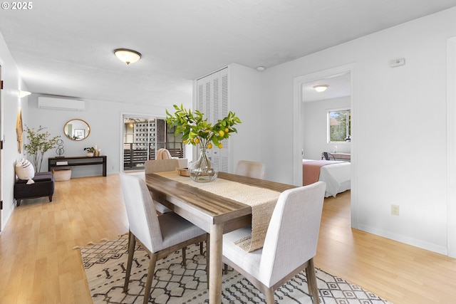 3038 SW Florida Ct Unit B, Portland, OR 97219 - dining area with light wood-type flooring, an AC wall unit, and baseboards