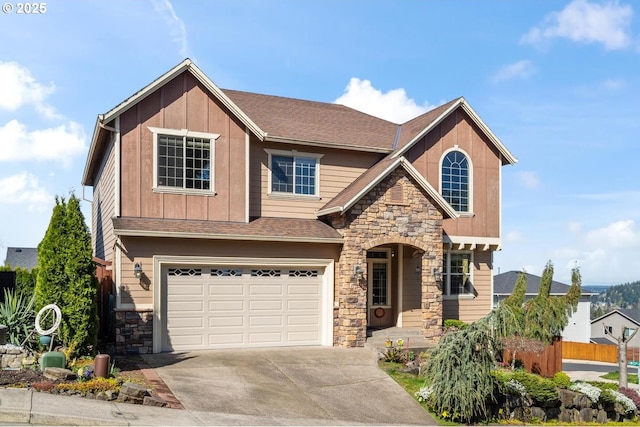 craftsman house featuring stone siding, fence, a garage, concrete driveway, and board and batten siding