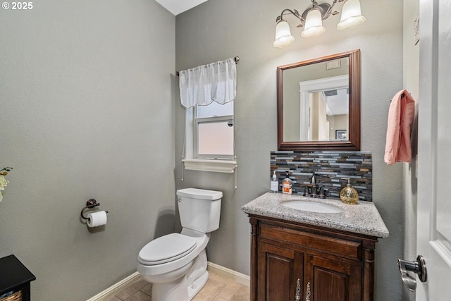 half bathroom featuring vanity, toilet, baseboards, tile patterned floors, and a chandelier