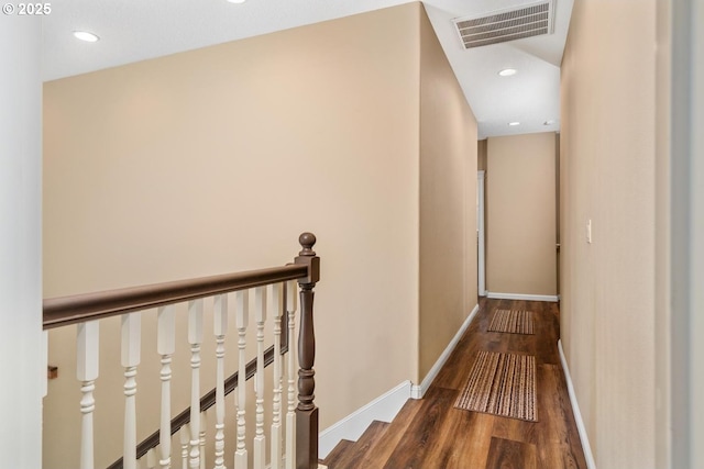 hall featuring visible vents, wood finished floors, baseboards, recessed lighting, and an upstairs landing