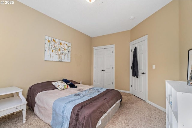 bedroom with baseboards and light colored carpet