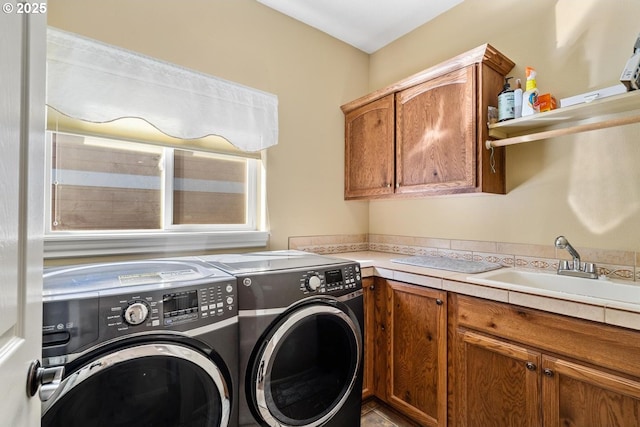 laundry room with a sink, separate washer and dryer, and cabinet space