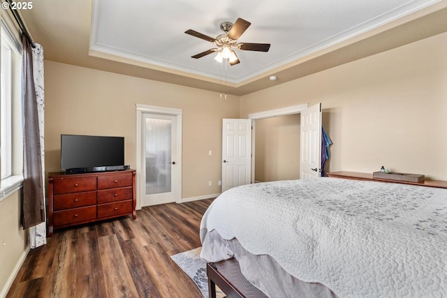 bedroom featuring baseboards, ceiling fan, a tray ceiling, and dark wood-style floors