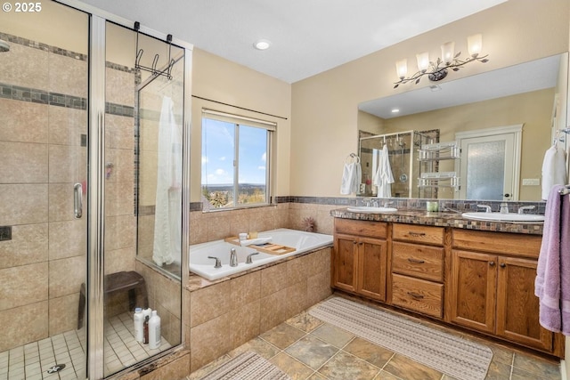 bathroom with double vanity, a sink, a bath, and a stall shower