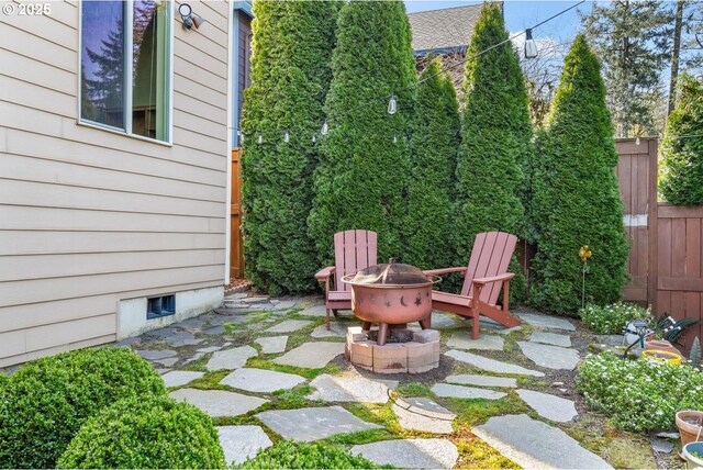view of patio with fence and a fire pit