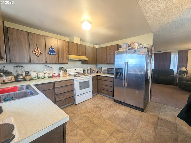 kitchen with white electric stove, sink, a textured ceiling, and stainless steel fridge