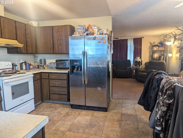 kitchen featuring dark brown cabinetry, white range with electric cooktop, a textured ceiling, light carpet, and stainless steel fridge