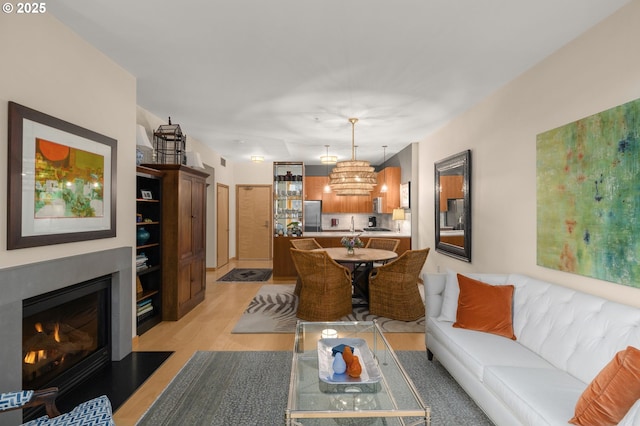 living room with light wood-type flooring and a notable chandelier