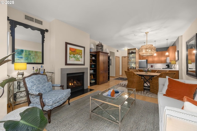 living room featuring light wood-type flooring and a chandelier