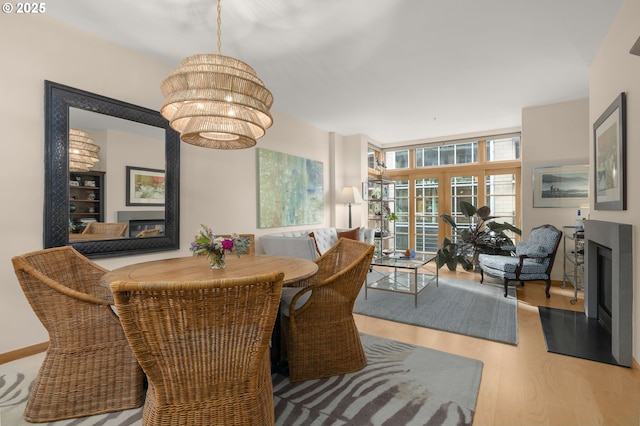 dining area featuring wood-type flooring and a notable chandelier