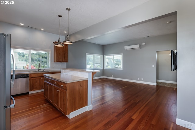 420 Bryant St, Clatskanie, OR 97016 - kitchen with stainless steel appliances, a sink, a wall mounted AC, dark wood-type flooring, and brown cabinetry