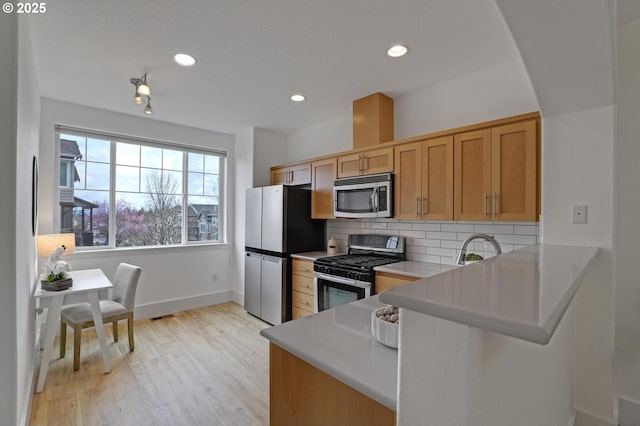 742 NW 118th Ave Unit 102, Portland, OR 97229 - kitchen with stainless steel appliances, light wood-style flooring, decorative backsplash, light countertops, and recessed lighting