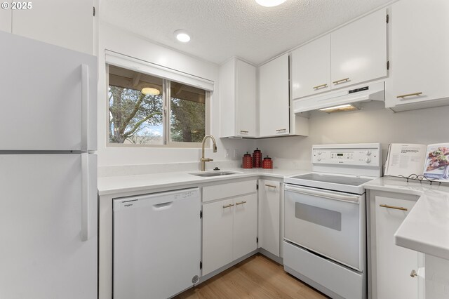 kitchen with sink, white cabinets, white appliances, a textured ceiling, and light hardwood / wood-style flooring