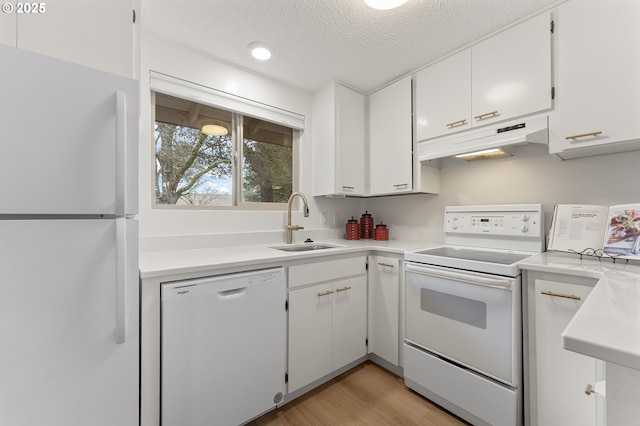 kitchen featuring sink, white appliances, light hardwood / wood-style flooring, white cabinetry, and a textured ceiling