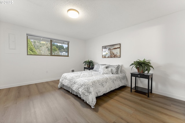 bedroom with wood-type flooring and a textured ceiling