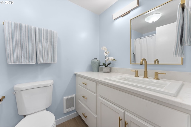 bathroom with vanity, toilet, and hardwood / wood-style floors