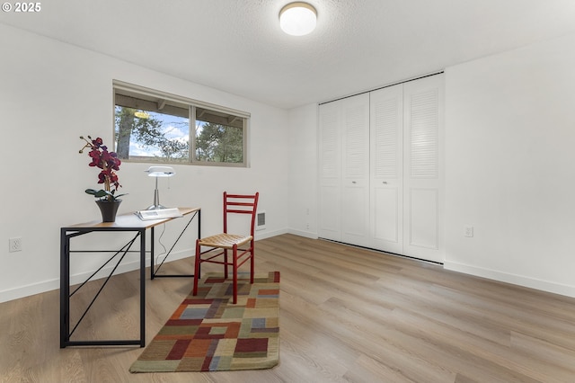 office featuring light hardwood / wood-style flooring and a textured ceiling