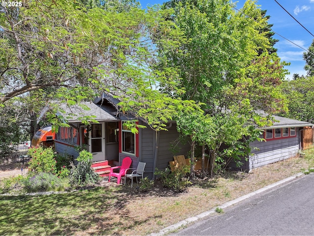 317 E 14th St, The Dalles, OR 97058 - view of front of property with a sunroom and roof with shingles