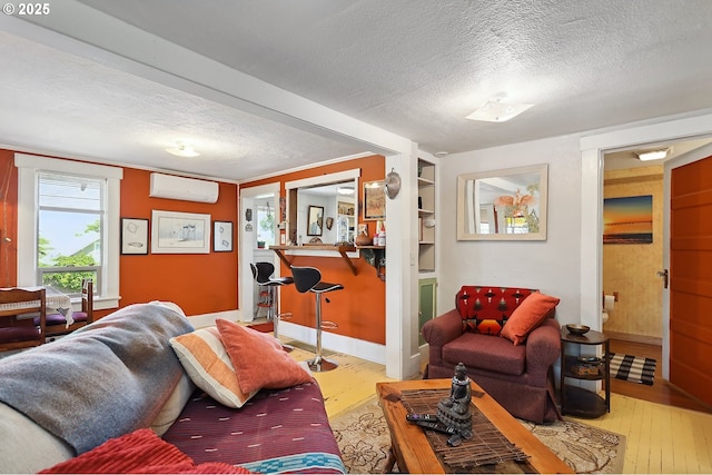 317 E 14th St, The Dalles, OR 97058 - living room with hardwood / wood-style floors, a textured ceiling, a wall unit AC, and baseboards