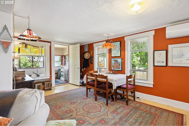 317 E 14th St, The Dalles, OR 97058 - dining room featuring a wall mounted air conditioner, a textured ceiling, wood finished floors, and baseboards