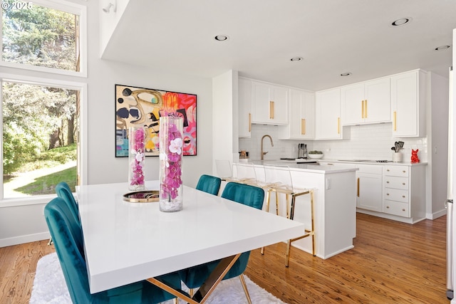 dining space featuring baseboards, light wood-style floors, and recessed lighting