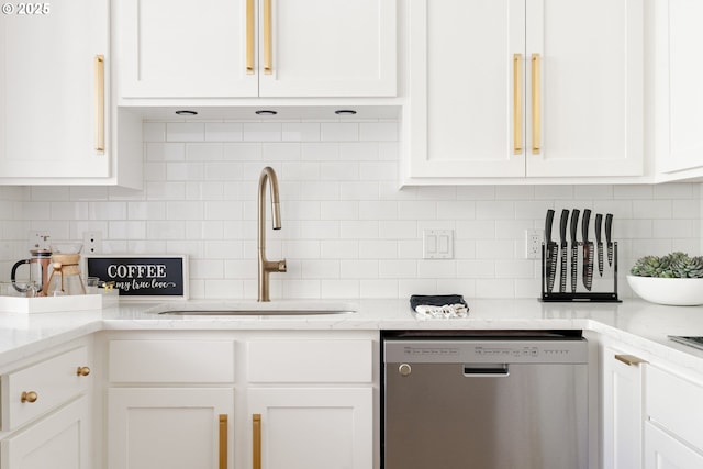 kitchen with white cabinets, tasteful backsplash, dishwasher, and a sink