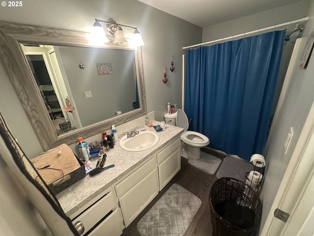 bathroom featuring walk in shower, vanity, toilet, and hardwood / wood-style floors