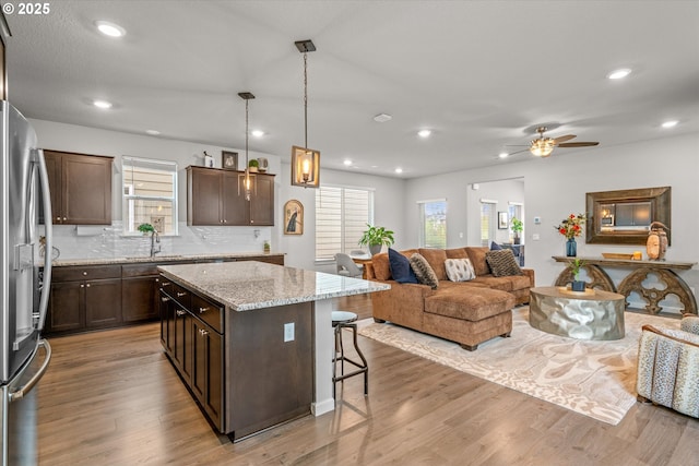 3477 SE Salmonfly Ln, Hillsboro, OR 97123 - kitchen featuring open floor plan, stainless steel refrigerator, dark brown cabinets, a breakfast bar, and a center island